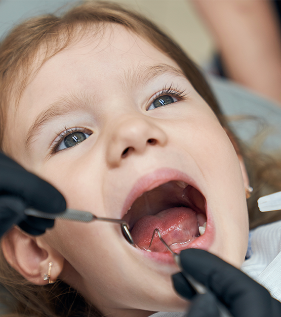 dentista examinando a condicao dos dentes do pequeno paciente